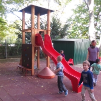 Kinderspielplatz im Kindergarten mit Spielturm und Kletterwand mit bunten Griffen