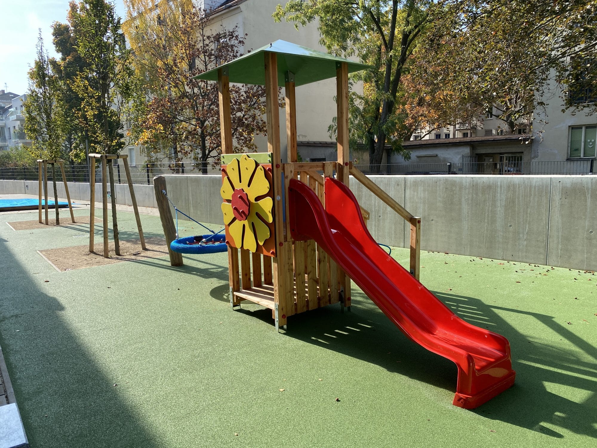 Spielturm mit roter Rutsche einer großen Blume zum drehen