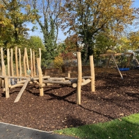 Erlebnisspielplatz mit Balancierbalken und Nestschaukel