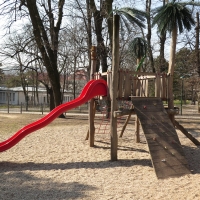 Spielplatzanlage von FREISPIEL mit Palmen am Spielturm und Kletterwand