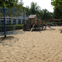 Spielplatz mit Spielhaus und Kletterpyramide auf gereinigten Sand