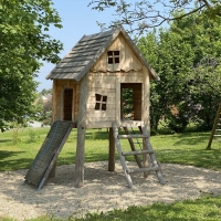 Baumhaus für Kinder auf Wiese auf Stelzen mit Leiter