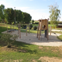 Wunderschöner Spielplatz aus Naturhölzer im Schatten von Bäumen