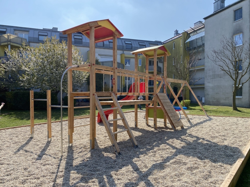 Doppelturmanlagen mit Nestschaukel auf Spielplatz in Wohnanlage