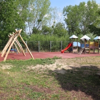 Spielplatz mit vielen Spielmöglichkeiten und rotem Fallschutz