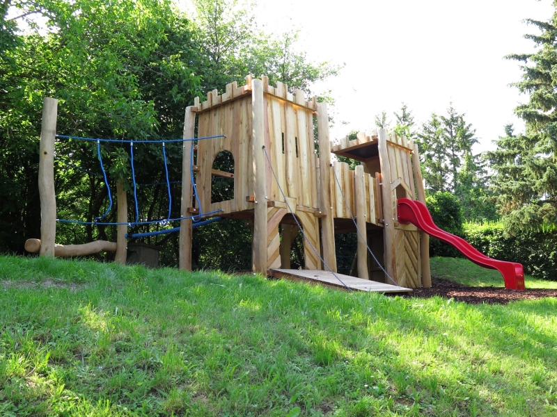 Burganlage von FREISPIEL Holzspielhaus mit Rutsche und Kletterpark