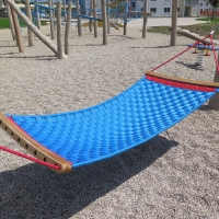 Geflecht-Hängematte auf Spielplatz auf Kieseluntergrund für Kinder