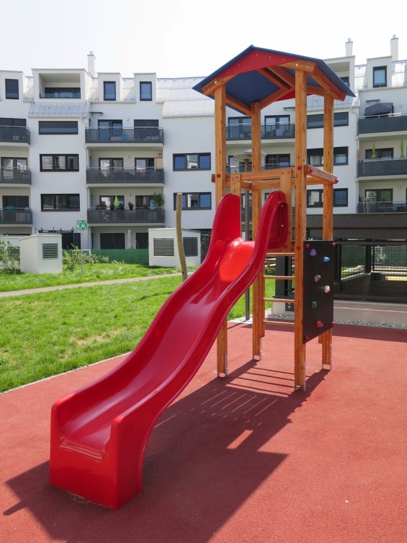 Rutschenturm mit Dach und Kletterwand auf dem Spielplatz