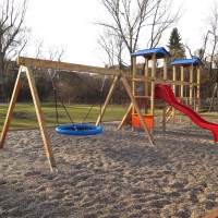 Vielseitige Spielgeräte auf Kiesbett im Kindergarten