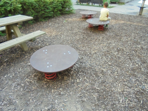 Drei große Hüpfplatten auf dem Spielplatz mit roten Federn