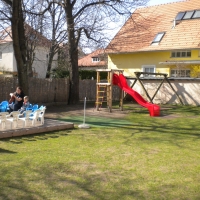 Spielplatz eines Kindergartens mit Rutsche und Doppelschaukel