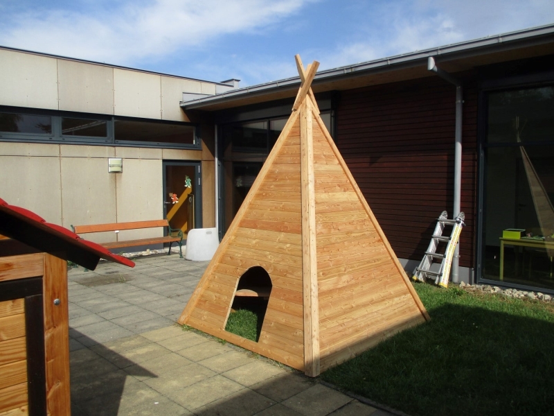 Indianer Tipi aus Holz auf dem Rasen im Kindergarten