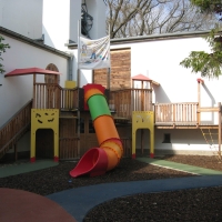 Bunter Spielplatz mit Röhrenrutsche und verschiedene Podeste aus Holz