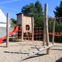 Öffentlicher Spielplatz mit roter Rutsche und Kletterpark