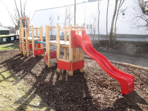 Spielanlage in Rot mit viel Holz und roter Rutsche von FREISPIEL