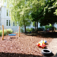 Kinderspielplatz mit Nestschaukel und Spielhaus