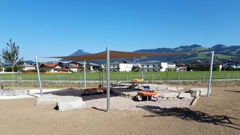 Hochwertiges Sonnensegel über eine Sandkiste auf einem Spielplatz