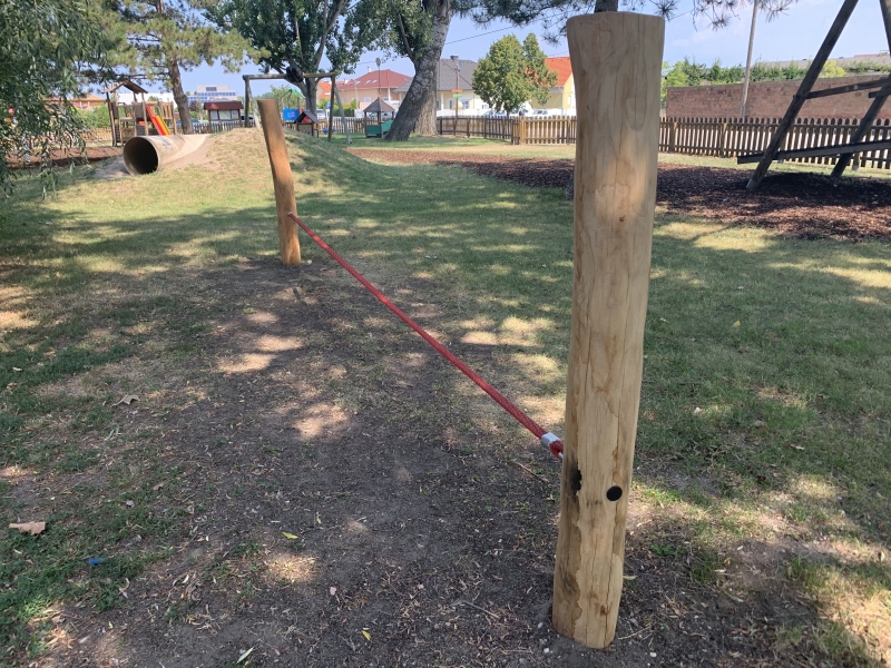 Slackline zwischen zwei Holzstehern auf einem Spielplatz