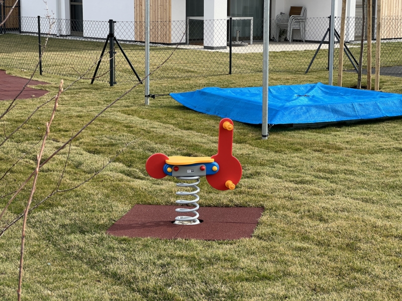 Rote Federwippe in Moped Form auf einem Spielplatz